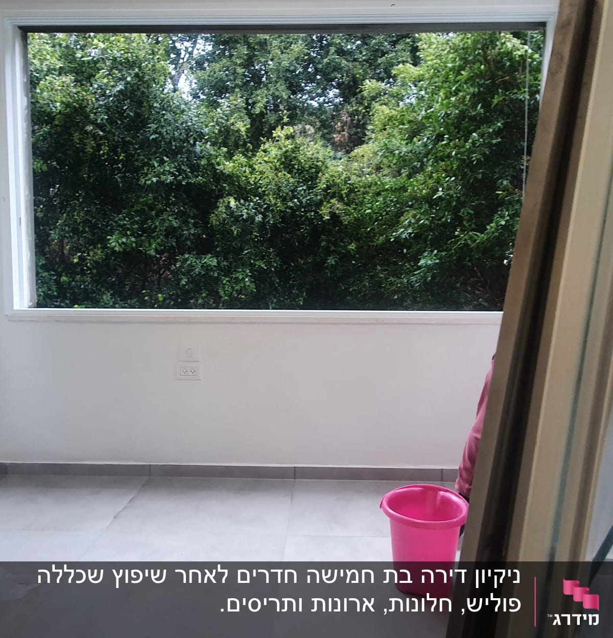 דלי ורוד על רצפה ליד חלון פתוח